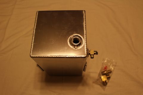 2003 Ford Crown Victoria - End view of a welded aluminum fuel cell with a raised welded bung and brass fitting, shown beside a bag of brass parts.