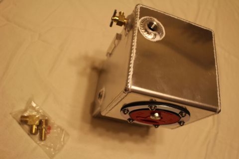 2003 Ford Crown Victoria - polished aluminum fuel cell sits on a white sheet, fitted with a red-and-black quick-fill cap and a bagged set of brass fittings nearby.