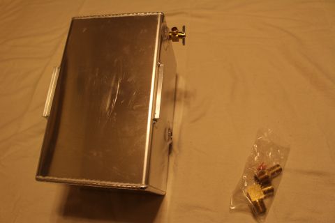 2003 Ford Crown Victoria - aluminum fuel cell lies on its side showing a brass valve, with a bag of brass fittings resting nearby.