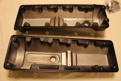 2003 Ford Crown Victoria - matched pair of black plastic engine valve covers, cast with 'TFS-FMOD-VC-L', lie upside down showing their ribbed interiors.