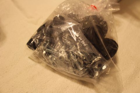 2003 Ford Crown Victoria - clear plastic bag holds an assortment of black rubber bushings and zinc-plated bolts and mounting hardware.