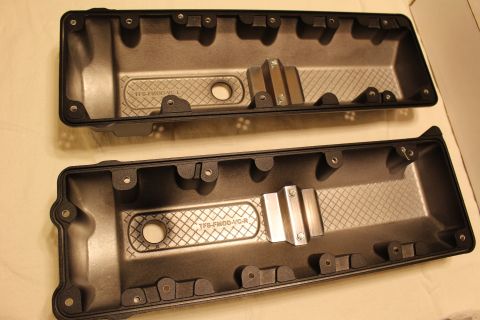 2003 Ford Crown Victoria - Two dark valve covers placed upside down on a white surface, showing crosshatched baffling and aluminum mounting blocks.