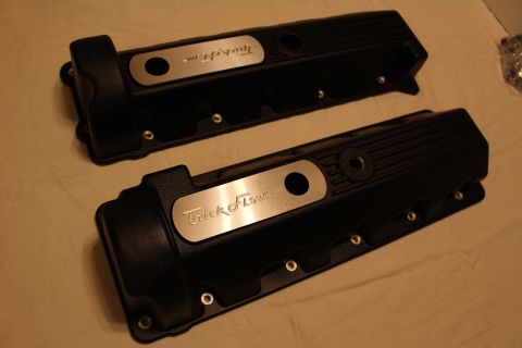 2003 Ford Crown Victoria - pair of black finned valve covers on a tan cloth, each topped with a brushed aluminum plate engraved Trick Flow.