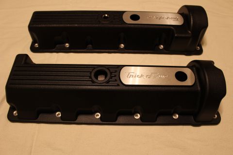 2003 Ford Crown Victoria - Two black engine valve covers with polished Trick Flow logo plates arranged at an angle on a tan cloth.
