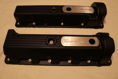 2003 Ford Crown Victoria - pair of black finned valve covers with engraved polished Trick Flow inserts displayed on a tan cloth.
