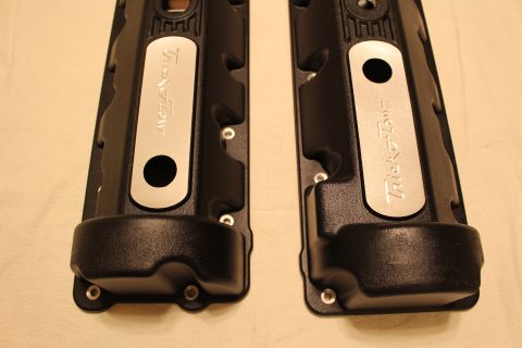 2003 Ford Crown Victoria - End-on view of two black finned valve covers with polished Trick Flow insert plates on a tan surface.