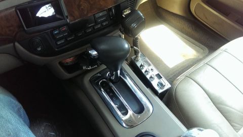 2000 Mercury Grand Marquis - The interior of a car shows the center console, gear shifter, and a CB radio mounted to the side.