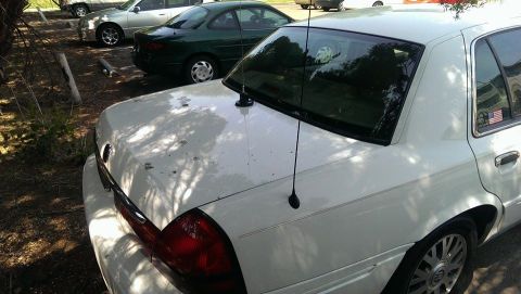 2000 Mercury Grand Marquis - A white sedan is parked in a lot with other vehicles visible in the background.