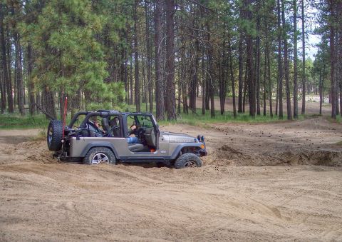 2005 Jeep Wrangler - A Jeep Wrangler is stuck in the sand while off-roading in a wooded area.