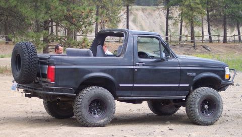 2005 Jeep Wrangler - Side view of a black Ford Bronco modified for off-road use.