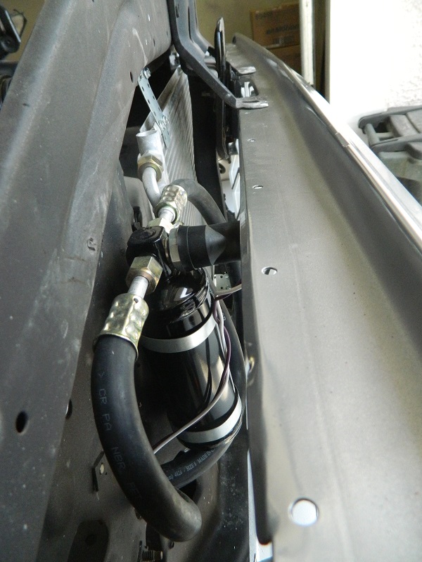 Air conditioning accumulator with hoses and mounting bracket