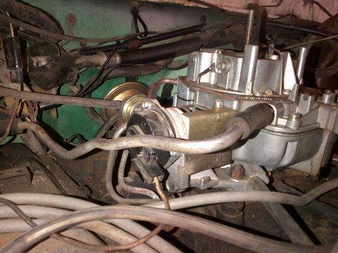 1978 Ford Bronco - A close-up view of a vehicle's engine bay, focusing on the carburetor and associated plumbing.