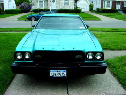 1973 Ford Ranchero - A teal 1973 Ford Ranchero is parked in front of a suburban house, with another blue car in the background.