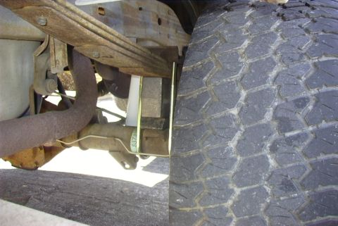 1995 Ford Bronco - Close-up view of a vehicle's rear suspension components and tire, showing modifications for lift.