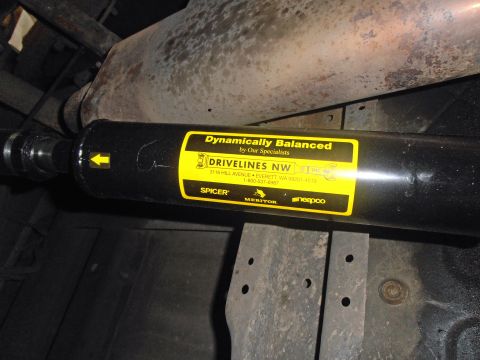 1990 Ford Bronco - Close-up of a driveshaft, a label from Drivelines NW with contact information and brand names.