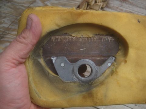 1993 Ford Bronco - A hand holds a piece of yellow seat foam, revealing a metal bracket mechanism embedded within.