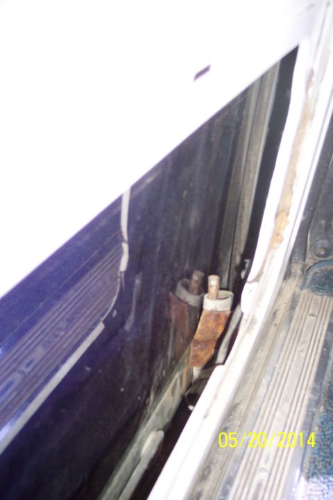 1990 Ford Bronco - Close-up view of the tailgate torsion bar mechanism, showing signs of rust and wear.