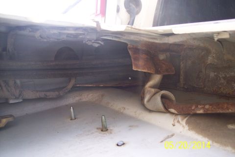 1990 Ford Bronco - Close-up view of rusted metal components and tubes, likely part of a vehicle's undercarriage.