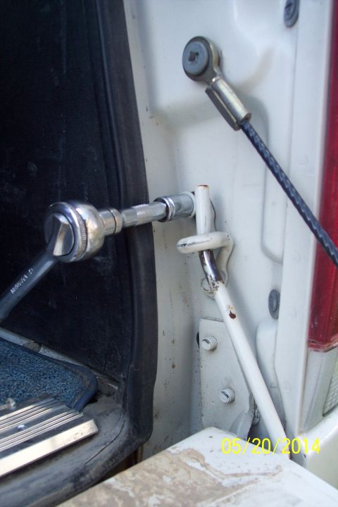 1990 Ford Bronco - Close-up of a socket wrench being used on a tailgate torsion bar mechanism, with a date stamp of 05/20/2014.