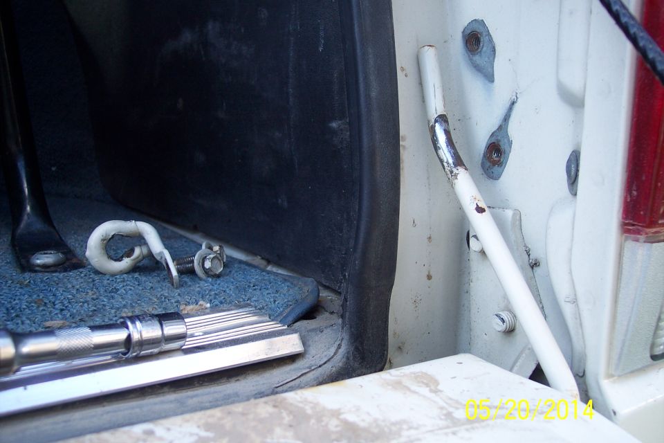 White tailgate torsion bar with mounting hardware and a socket wrench on blue carpet