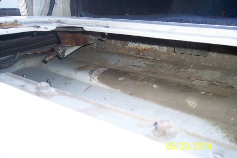 1990 Ford Bronco - The torsion bar mechanism for a vehicle's tailgate shows signs of rust and wear.