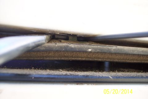 1990 Ford Bronco - Detail of the tailgate torsion bar mechanism, showing accumulated dust and dirt.
