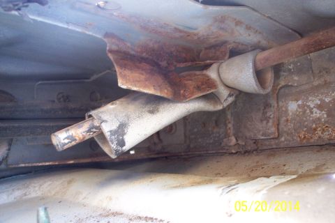 1990 Ford Bronco - Close-up of a corroded tailgate torsion bar mechanism, showing significant rust and wear.