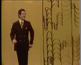 2000 Mercury Grand Marquis - A man in a suit walks past a textured yellow wall with vertical text.