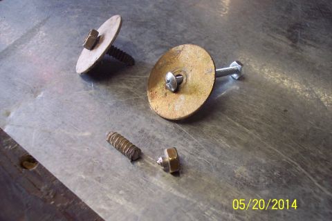 1990 Ford Bronco - Hardware components, including screws, washers, and nuts, are laid out on a metallic surface.