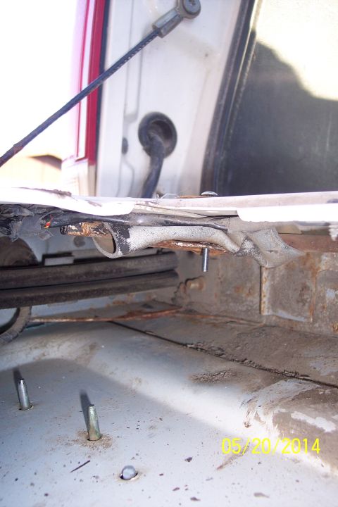 1990 Ford Bronco - Close-up of a vehicle's tailgate torsion bar mechanism, showing signs of rust and wear.