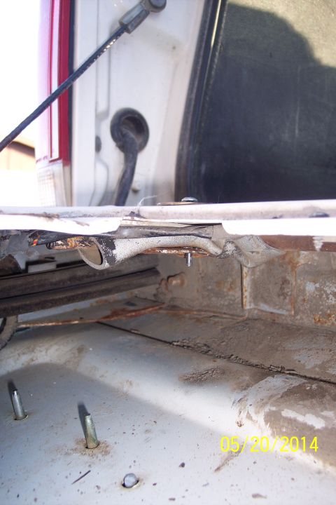 1990 Ford Bronco - Close-up of a corroded tailgate torsion bar mechanism, showing internal components and surface rust.