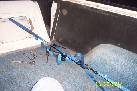 1990 Ford Bronco - Close-up of a tailgate torsion bar mechanism with straps and tools, suggesting repair or maintenance.