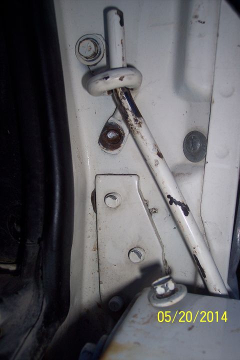 1990 Ford Bronco - Close-up view of the tailgate torsion bar mechanism, showing its mounting hardware and some signs of wear.