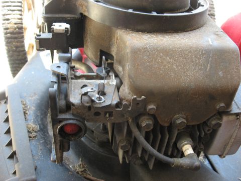 2006 Honda RANCHER - This image shows a close-up view of a lawn mower engine, highlighting the primer bulb and spark plug.
