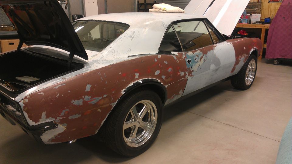 1969 Chevrolet Camaro in primer with trunk and hood open, undergoing bodywork