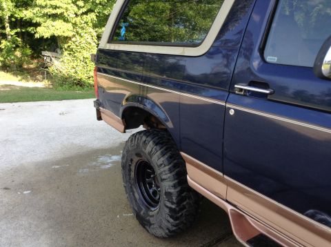 1995 Ford Bronco - This Ford Bronco has a distinctive body style and tan trim, suggesting a model year in the early to mid-1990s.