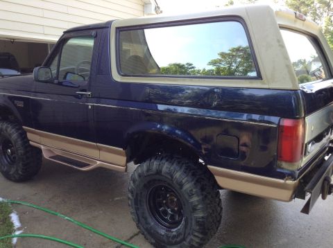 1995 Ford Bronco - Side view of a lifted Ford Bronco with aftermarket wheels and tires.