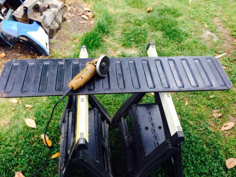 1979 Ford Bronco - An angle grinder sits on a tailgate, ready for modification outdoors.