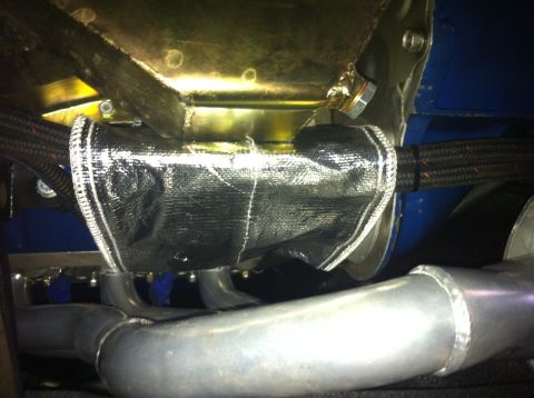 1982 Ford Bronco - Close-up of an engine part wrapped in heat-resistant material, showing braided hoses and exhaust manifold.