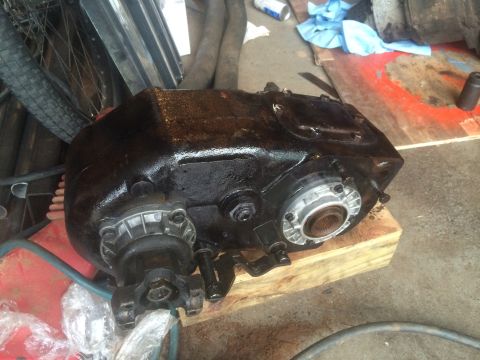 1991 Ford F-250 - A black transfer case sits on wooden blocks, ready for installation or repair.
