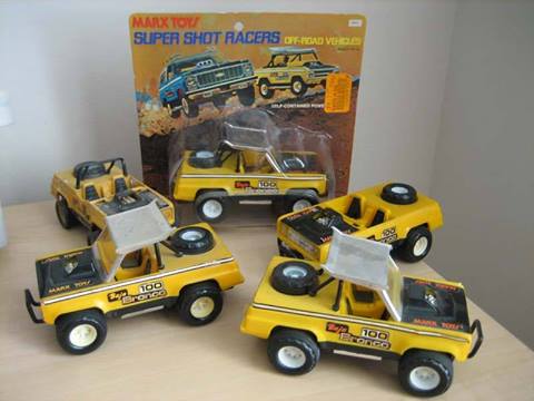 1990 Ford Bronco - Multiple yellow Marx Toy Super Shot Racers "Baja 100 Bronco" off-road vehicles are displayed in and out of their original packaging.