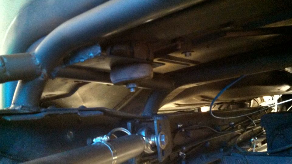 Underside view of exhaust pipes and frame with visible bolts and clamps