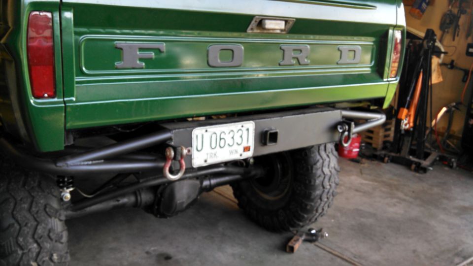 Green Ford truck rear with custom bumper, tow hooks, and license plate U 06331