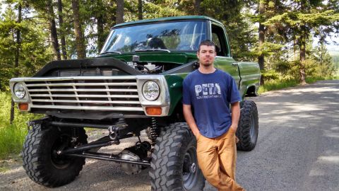 1967 Ford F-250 - A man poses with his modified 1967 Ford F-250 pickup truck, a lifted suspension and open hood.