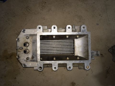 1996 Ford Bronco - Close-up of an aluminum supercharger housing, showing internal fins and threaded ports.