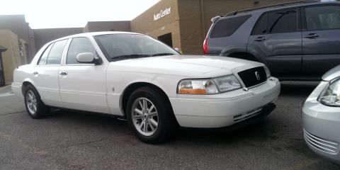 2000 Mercury Grand Marquis - This 2000 Mercury Grand Marquis is seen in a parking lot next to an SUV and another car.