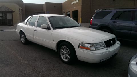 2000 Mercury Grand Marquis - White 2000 Mercury Grand Marquis parked in a lot with a dark SUV nearby.