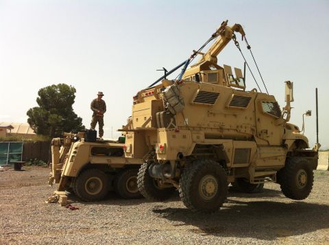 1994 Ford Bronco - A military tow truck is shown with a soldier standing on its rear chassis in an outdoor setting.