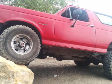 1988 Ford Bronco - This red 1988 Ford Bronco is shown from the side, with one wheel resting on a rock.