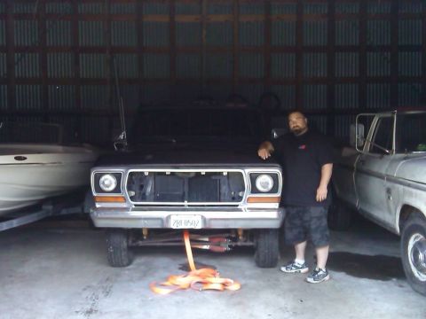 1978 Ford Bronco - A man poses with a 1978 Ford Bronco parked in a garage next to a boat and another truck.